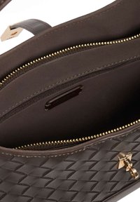 Brown woven leather handbag interior with gold zippers and hardware, featuring two zippered compartments and a smooth lining.