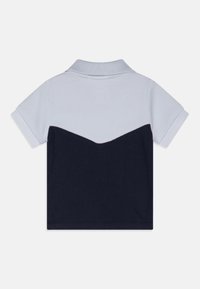 Donkerblauwe en lichtgrijze polo met korte mouwen, gemaakt van textiel met structuur, voorzien van een ribbelkraag en een contrasterend chevronontwerp.