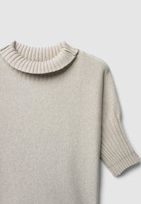 Kurzarmpullover in creme mit geripptem Rollkragen und strukturiertem Körper. Der Stoff wirkt weich und leicht.