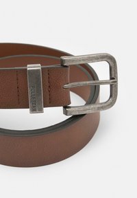 Cureau maroșcat texturat cu o cataramă metalică argintie. Dispune de o cataramă rectangulară cu un eticheta a mărcii, destinat purtării casual.