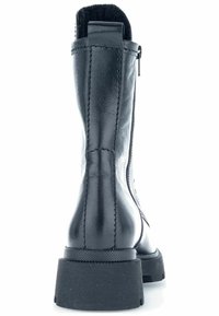 Black leather ankle boot with a textured finish, rear zipper, stitched accents, and a chunky black rubber sole.