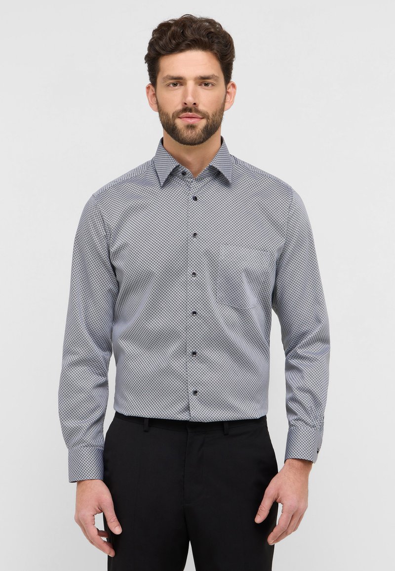 Camicia button-up in un motivo geometrico blu chiaro e bianco, maniche lunghe, colletto a punta e bottoni scuri. Tessuto morbido.