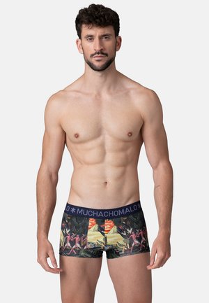 Herrenslips mit buntem tropischem Muster, ausgestattet mit einem enganliegenden Design und einem dunklen Bund mit "MUCHACHOMALO" Branding.