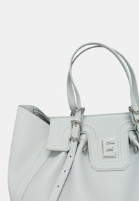 Borsa tote in pelle grigia chiara con finitura testurizzata, dotata di dettagli in argento e una lettera "E" stilizzata sul davanti. Due manici robusti.