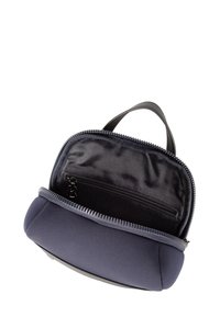 Torba iz mornarsko modrega blaga z zadrgo, opremljena z ročajem in črto podlogo. Notranjost vsebuje majhen žep z zadrgo za shranjevanje.