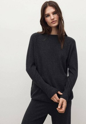 Suéter de punto gris oscuro con mangas largas, un corte relajado y puños acanalados. El material parece suave y texturizado, adecuado para el uso casual.