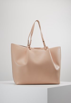 Beżowa torba na ramię wykonana z gładkiego, matowego materiału. Posiada dwa paski na ramię oraz pojemny, niekształtowany kształt bez widocznych elementów metalowych.