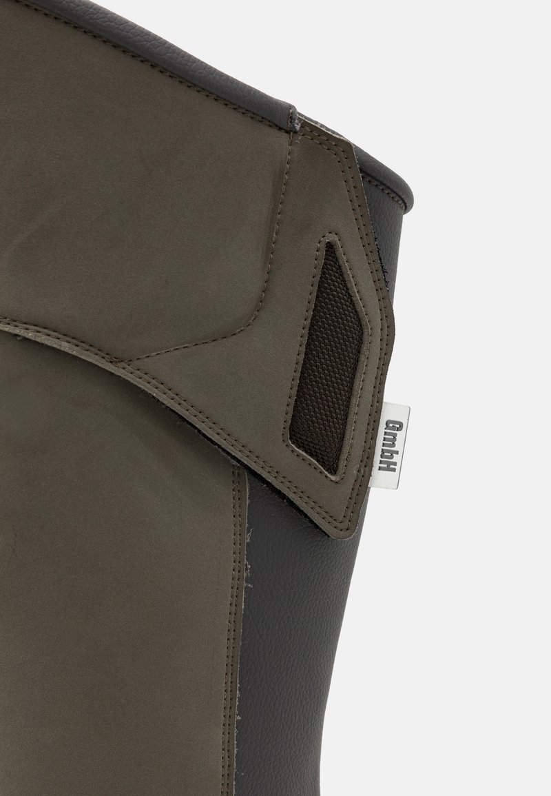 Donkergrijze rubberlaars met een gestructureerde bovenkant en een glad paneel. Opvallende details zijn een mesh zijaccent en een logo-tag.