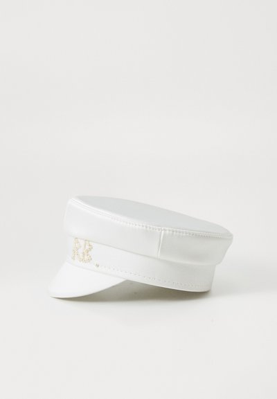 Valge sünteetilisest nahast müts, millel on lame ääreosa ja struktuurne ülemine osa, küljes dekoratiivne pärlitega kaunistatud monogramm.