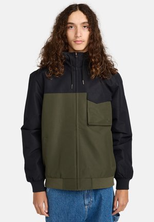 Kurtka w stylu color-block z czarną górną częścią i oliwkowo-zieloną dolną częścią, z zamkiem błyskawicznym z przodu, regulowanym kapturem i kieszenią na piersi.