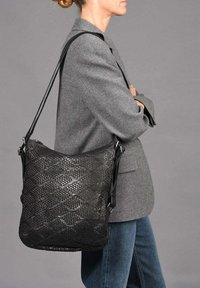 Zwarte geweven leren handtas met een gestructureerde vorm en verstelbare schouderband, voorzien van een gequiltde textuur en metalen accenten.