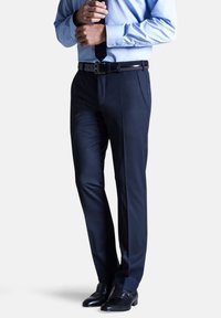 Marineblaue maßgeschneiderte Hosen aus glattem Stoff mit Fronttaschen, im Slim-Fit-Schnitt und mit dezenten Falten, kombiniert mit schwarzen Dressschuhen.