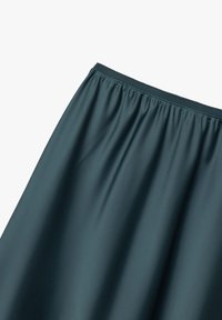Jupe bleu foncé avec taille élastique, présentée sur un fond blanc uni, avec un tissu qui tombe en douces plis.