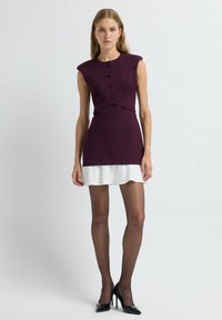 Robe ajustée avec un bustier bordeaux profond, une jupe blanche évasée, un col rond et des détails en boutons ; texture lisse avec de courtes manches à la capuche.