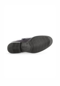 Semelle de chaussure en caoutchouc noir, présentant des rainures et des crêtes pour une meilleure adhérence. Nom de la marque « Gabor » estampé sur le côté. Surface lisse avec un léger brillant.
