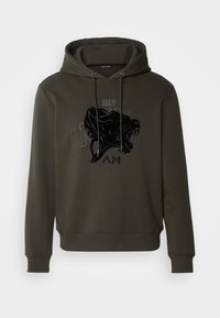 Sweat à capuche vert olive, avec un design de lion graphique noir et du texte sur le devant. Fabriqué en tissu doux et texturé.