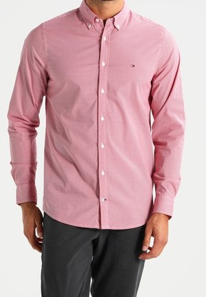 Rot-weiß kariertes Langarmhemd mit Button-Down-Kragen und kleinem Logo auf der linken Brust. Hergestellt aus gewebtem Baumwollstoff.