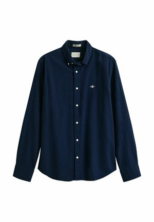 Dunkelblaues, langärmliges Hemd mit Knopfleiste, mit Knopfkrause und kleinem aufgesticktem Logo auf der linken Brust.