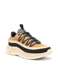 Kengät beige ja mustana, joissa on teksturoitu kangasyläosa, paksu valkoinen pohja ja mustat nauhat. Varusteet punaiset ja harmaat yksityiskohdat sekä Gore-Tex -merkinnät.