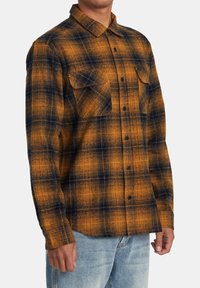 Orange und marineblaue karierten Flanellhemd mit langen Ärmeln, zwei Brusttaschen, Knopfverschluss und lässigem Schnitt. Strukturiertes Stoffmuster sichtbar.