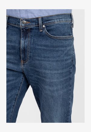 Dunkelblaue Denim-Jeans mit glatter Textur, ausgestattet mit Kupfernähten, einem Knopfverschluss und vorderen Taschen.