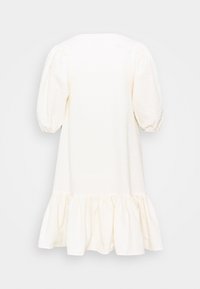 Weißes, strukturiertes Kleid mit gepufften ärmellangen Ärmeln und einem gerafften Volant-Saum, auf einem schlichten hellen Hintergrund präsentiert.