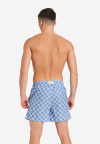 Shorts da nuoto in azzurro chiaro con un motivo geometrico, dotati di vita elasticizzata e vestibilità casual, realizzati in tessuto leggero.