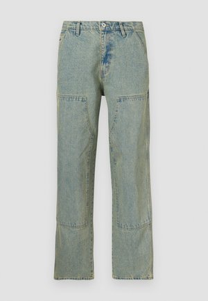 Lyseblå denimjeans med løs pasform, der har lap-patch-detaljer på forlommerne og en let falmet tekstur.