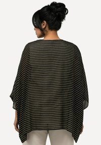 Schwarzer transparenter Poncho mit weißen horizontalen Streifen, breiten Ärmeln und lockerer Passform. Leichtes Material fällt sanft über den Körper.