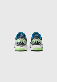 Pair of black, blue, green, and white athletic shoes with cushioned soles, shown from the back on a white background.