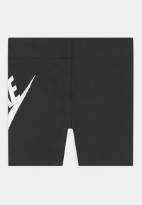 Pantaloni corti sportivi neri realizzati in tessuto misto cotone, con un prominente logo Nike bianco sul lato sinistro. Cuciture visibili sulle giunzioni.