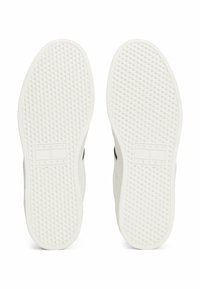 Suela de zapatilla blanca con patrón de diamantes texturizado, con un acento negro y el logo "TOMMY JEANS" en el centro.