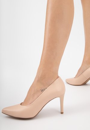 Scarpe con tacco alto di color rosa chiaro con punta appuntita e un design a taglio curvo. Realizzate in pelle liscia con un sottile tacco a stiletto.
