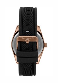 Zwarte rubberen strap horloge met een hexagonale roségouden kast, getextureerde accenten, een roestvrijstalen achterkant en een gemusterde band voor ventilatie.