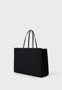 Czarna torba tote z fakturą, z dwiema mocnymi uchwytami, ozdobiona geometrycznym wzorem na zewnątrz. Prostokątny kształt z płaskim dnem.