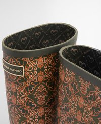 Barbour Farm Rio waterproof boots feature a dark green floral pattern with copper accents. Rubber exterior, textured rim, and patterned interior lining.