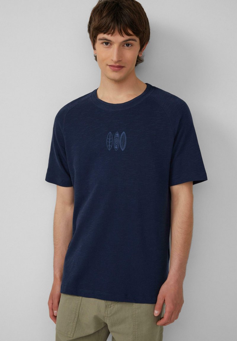 Dunkelblaues T-Shirt mit kurzen Ärmeln aus strukturiertem Stoff, das drei hellblaue Surfbrett-Designs auf der Brust zeigt.