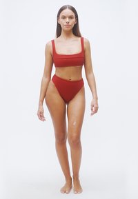 Κόκκινο ριμπ μπικίνι σετ με τοπ με τετράγωνη λαιμόκοψη και φαρδιές τιράντες, καθώς και σλιπ με ψηλή μέση. Λιτή υφή, εφαρμοστό σχέδιο.
