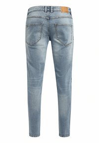 Lyseblå denimjeans med slank passform, fem lommer, og en rektangulær lærflekk på baklinningen. Falmet tekstur på stoffet.
