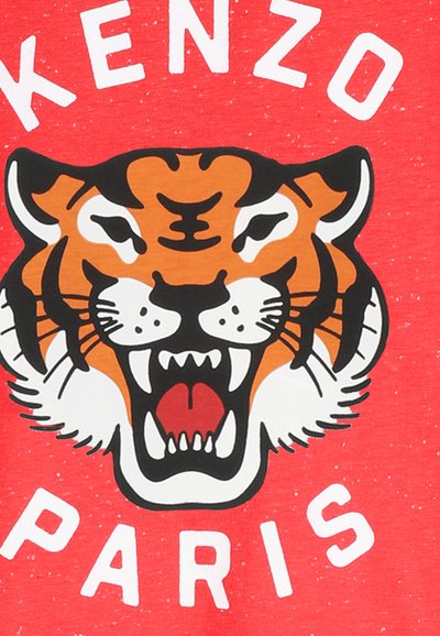 Czerwona koszulka z krótkim rękawem z dużym nadrukiem twarzy ryczącego tygrysa w kolorach pomarańczowym, czarnym i białym, z napisem "KENZO PARIS" poniżej.