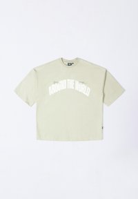 Light green, oversized short-sleeve t-shirt made of cotton. Features white text "AROUND THE WORLD" and a small graphic on the left chest.