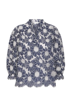 Tmavomodrá blúzka s bielym kvetinovým čipkovým vzorom, má výstrih do V, nafúknuté rukávy a okraje s vlnitým lemom. Ľahká, priesvitná látka.