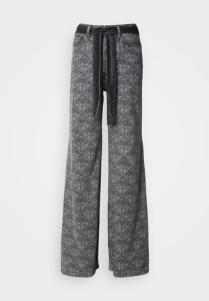 Wide-leg jeans in denim with a geometric pattern, featuring a dark waistband and tie detail. Color scheme is predominantly grey.