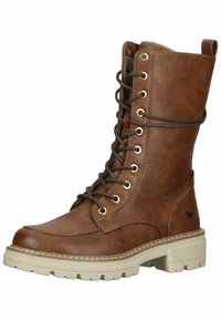 Botte en cuir marron à lacets avec un col rembourré, semelle en caoutchouc beige et œillets dorés, arborant un petit logo de cheval sur le côté.