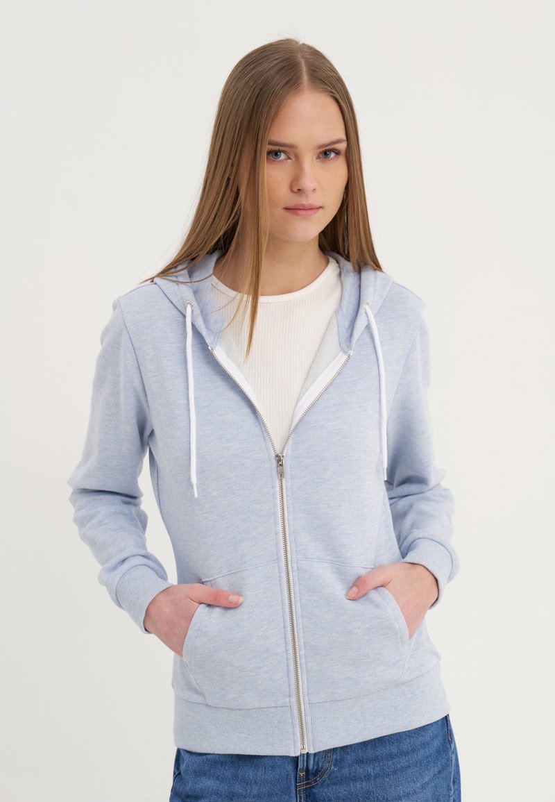 Sudadera con cremallera de color azul claro, hecha de tela suave, que cuenta con una capucha, cordones, dos bolsillos frontales y puños y dobladillo acanalados.