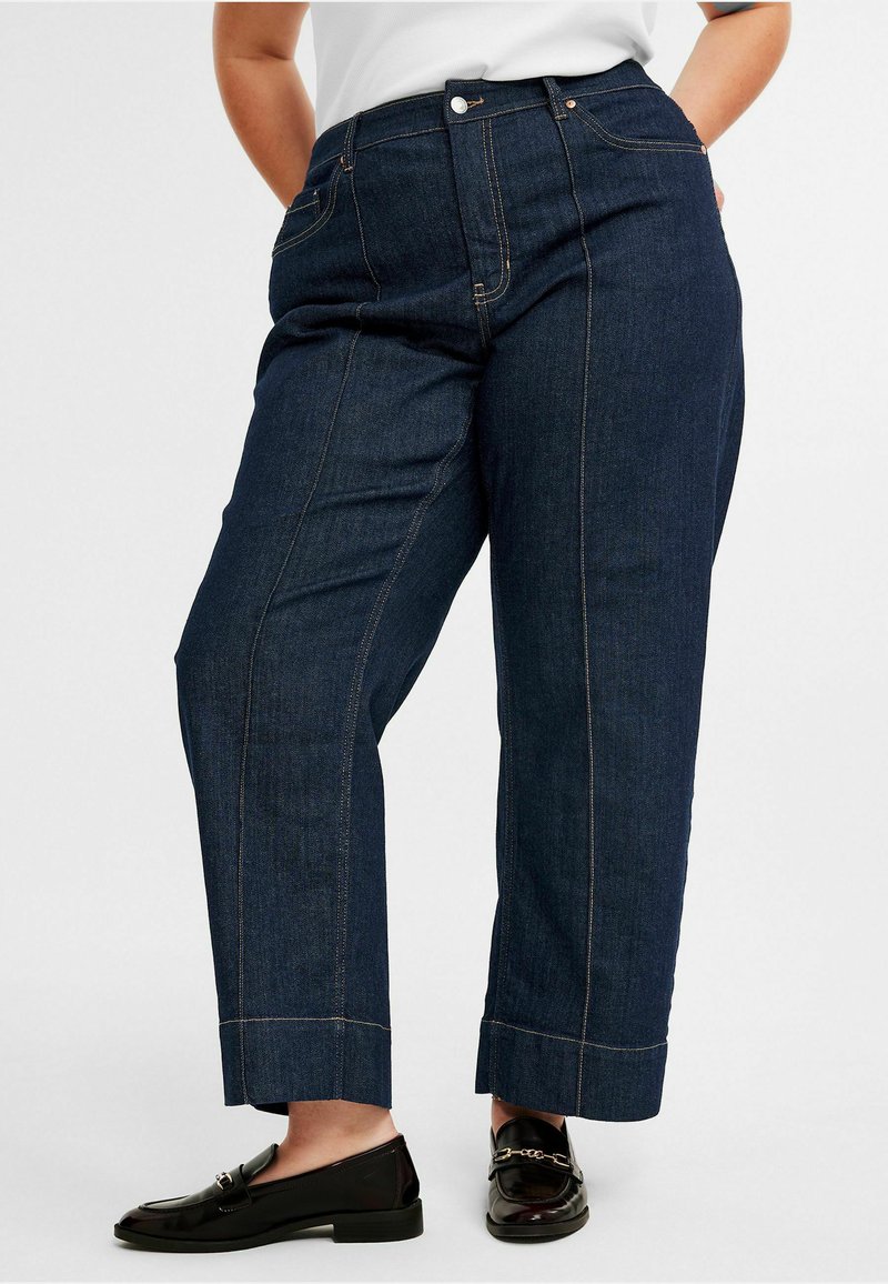 Tummansiniset denim-housut, joissa on rento istuvuus, korkea vyötärö, suora lahje ja kontrastiväriopastukset.