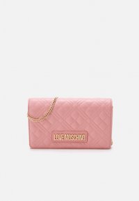 Quilted pink synthetic leather wallet with gold hardware, chain strap, and a logo plaque. Compact rectangular design with a textured finish.
