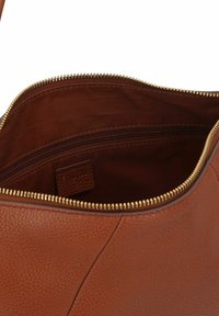 Borsa in pelle marrone aperta che mostra la fodera interna in tessuto e una tasca con zip con dettaglio della cerniera dorata.