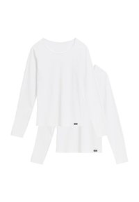 Dwie proste białe koszulki z długim rękawem i okrągłym dekoltem, nałożone jedna na drugą, z małymi czarnymi prostokątnymi metkami marki przy dolnym brzegu.