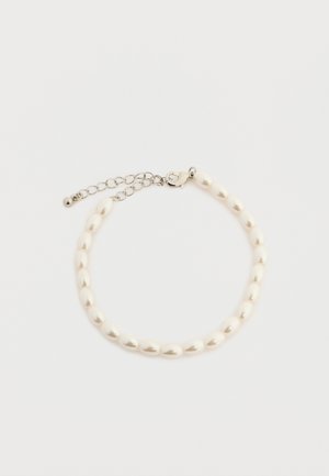 Karkötő kis ovális fehér gyöngyökkel és ezüst színű homárkapoccsal, állítható lánccal, egyszerű fehér háttéren.